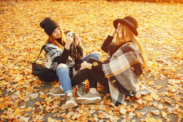 Dvě mladé dívky procházka po městě v podzimním městě a park — Stock fotografie