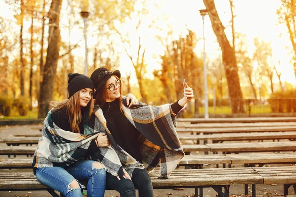 Duas meninas caminham pela cidade no outono cidade e parque — Fotografia de Stock