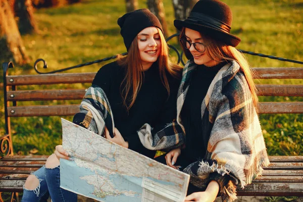 Två unga flickor gå runt i staden i höst stad och park — Stockfoto