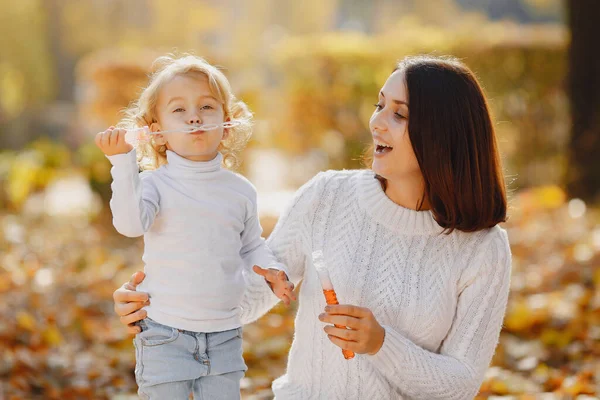 Мама з маленькою донькою грається з бульбашками. — стокове фото