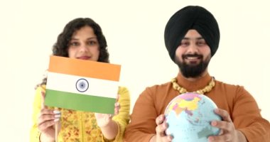 Genç adam ve Hintli kadın ellerinde küre ve bayrak tutuyorlar.