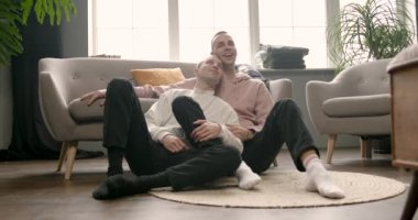 Memlekette birlikte televizyon izleyen mutlu eşcinsel çift.