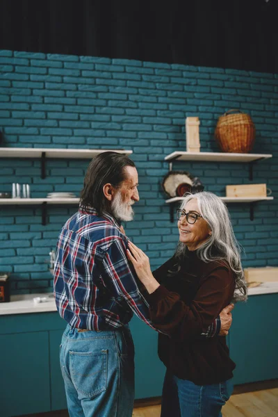 Smiling senior couple dancing in modern kitchen