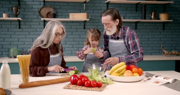 Grand-parents aînés couple avec petite-fille cuisine dans la cuisine — Video