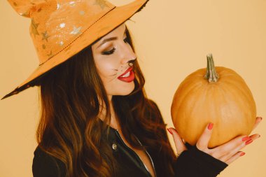 Cadılar bayramı kostümlü genç kadın arka planda poz veriyor