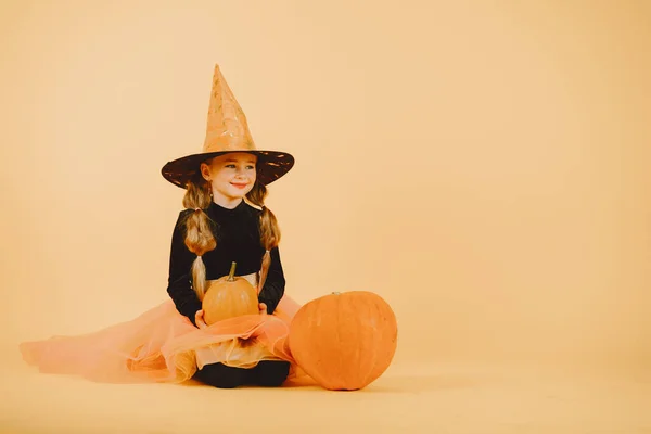 Gyönyörű lány boszorkány egy narancs háttér — Stock Fotó