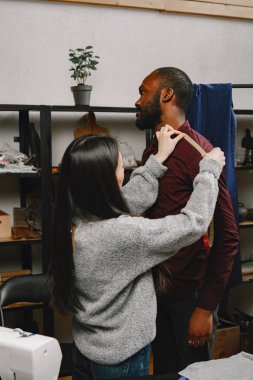 Koreli kadın terzi atölyedeki siyah adamı ölçüyor