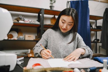 Atölyede çalışan profesyonel bayan terzi.