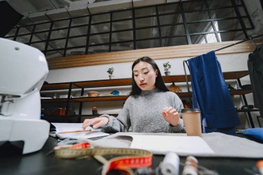 Atölyede çalışan profesyonel bayan terzi.