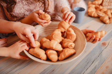 Sevimli kızlar mutfakta durup çörek yiyorlar.