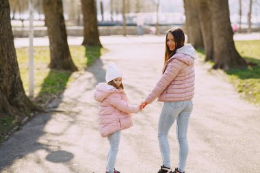 Anne ve kızı bir bahar parkında oynuyorlar.