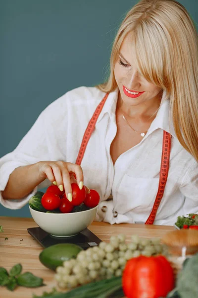 Menina bonita e desportiva em uma cozinha com um legumes — Fotografia de Stock