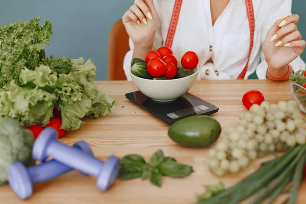 Menina bonita e desportiva em uma cozinha com um legumes — Fotografia de Stock