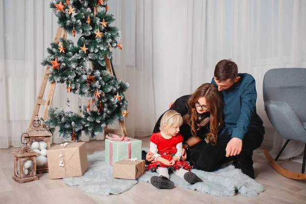 Familia sentada en casa cerca del árbol de Navidad — Foto de Stock