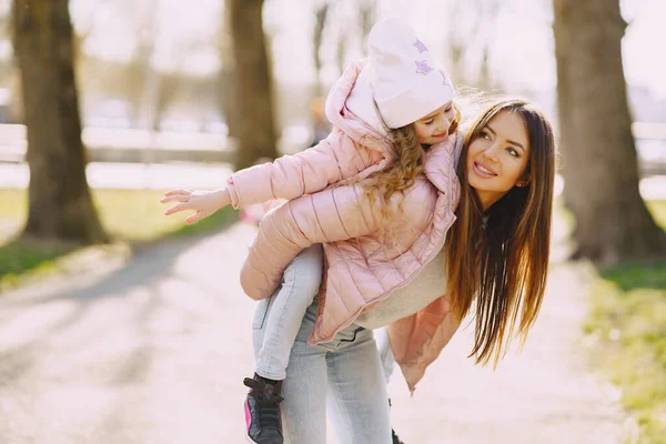 Mother with daughter playing in a spring park — Stock Photo, Image