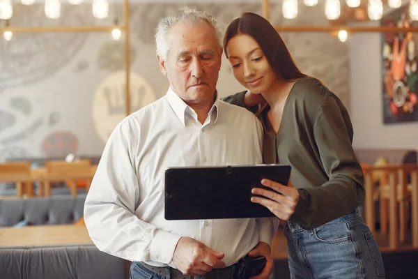 Mädchen bringt ihrem Großvater bei, wie man ein Tablet benutzt — Stockfoto