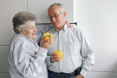 Güzel yaşlı çift mutfakta yemek hazırlıyor.