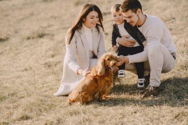 Bir bahar tarlasında yürüyen şık bir aile