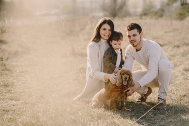 Bir bahar tarlasında yürüyen şık bir aile