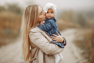 Anne ve kızı sonbahar tarlasında oynuyorlar.