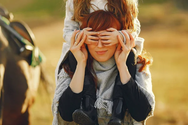 Madre e figlia in un campo a giocare con un cavallo — Foto Stock