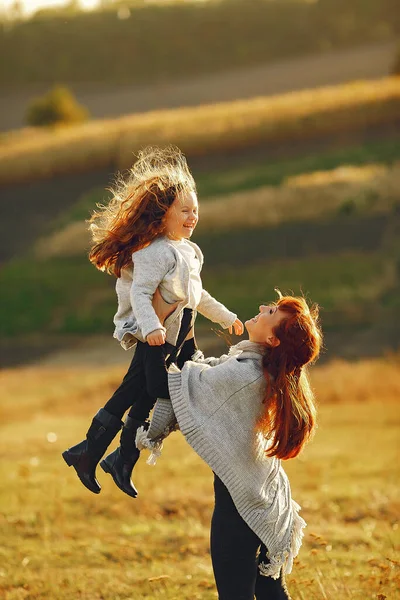 एक शरद ऋतु क्षेत्र में खेल रही छोटी बेटी के साथ माँ — स्टॉक फ़ोटो, इमेज