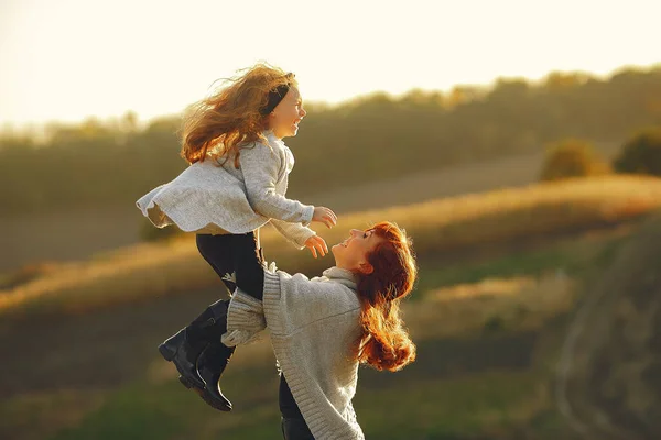 Mother with little daughter playing in a autumn field — Stock Photo, Image