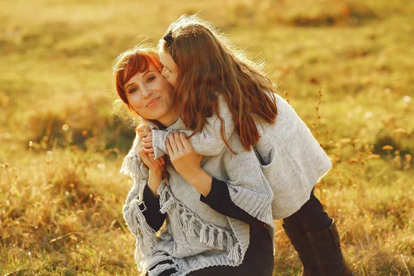 Madre con hija pequeña jugando en un campo de otoño — Foto de Stock