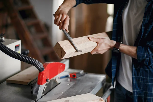 Man in de werkplaats met een hout — Stockfoto