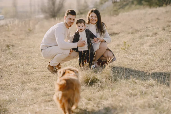 Família elegante que anda em um campo de primavera — Fotografia de Stock