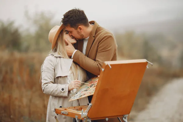 Pintura de casal elegante em um campo de outono — Fotografia de Stock