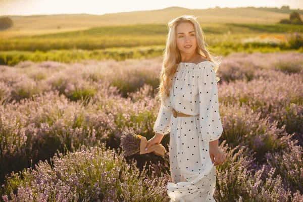 Vrouw in een witte jurk in een lavendelveld — Stockfoto