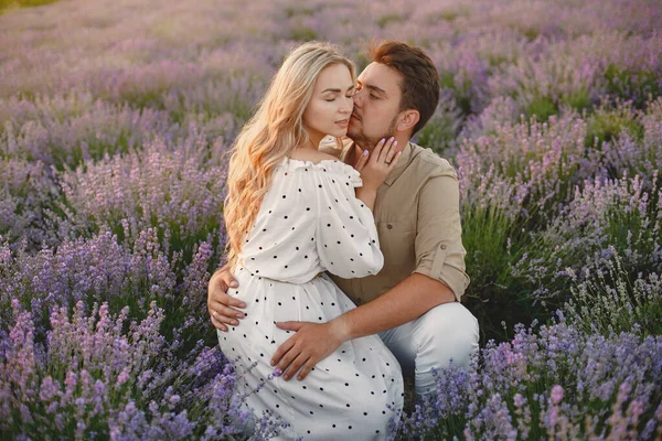 Frau im weißen Kleid mit ihrem Mann in einem Lavendelfeld — Stockfoto