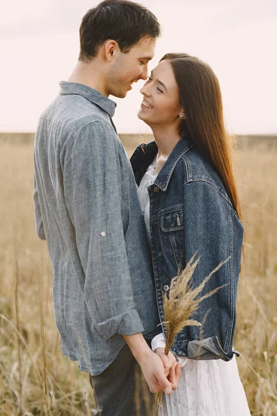 Feliz casal apaixonado no campo de trigo ao pôr-do-sol — Fotografia de Stock