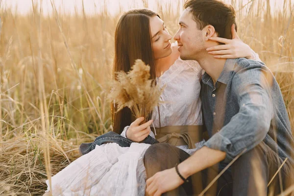 Lyckligt par kär i vetefält vid solnedgången — Stockfoto