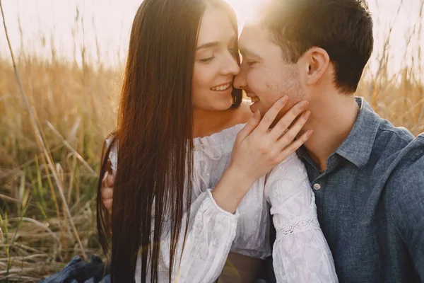Szczęśliwa para zakochana na polu pszenicy o zachodzie słońca — Zdjęcie stockowe