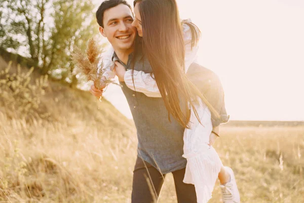 Pareja feliz enamorada en el campo de trigo al atardecer — Foto de Stock