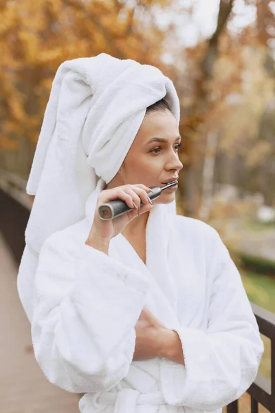 Foto van mooie vrouw in witte badjas — Stockfoto