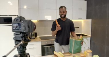 Afrikalı bir adam mutfakta erzak paketlerini açıyor.