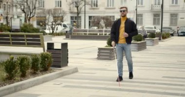 Kör adam şehirde tek başına yürüyor.