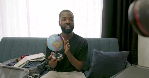 Afrykański bloger trzymający globus i filmujący blog — Wideo stockowe