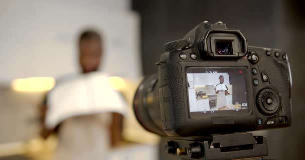 Chef americano africano com livro de receitas na cozinha — Vídeo de Stock