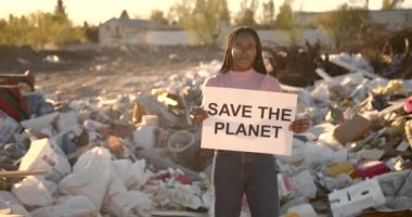 Elinde tutmakta olan Afrikalı Amerikalı kadın gezegen tabelasını kurtardı