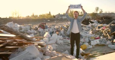 Çevre kirliliğine karşı yazıtı olan bir afiş tutan genç eylemci.