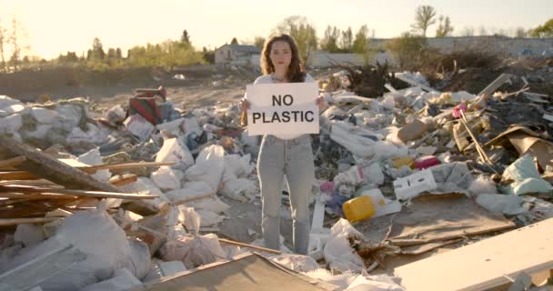 Молодая женщина без пластиковой вывески на мусорном баке — стоковое видео
