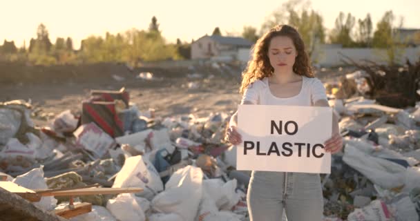 Молода жінка не тримає пластиковий знак на місці сміття — стокове відео
