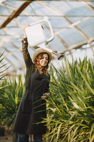 Mujer con camisa verde trabajando en un invernadero —  Fotos de Stock