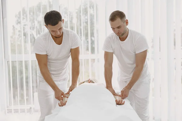 Quatro mãos fazem massagem ao corpo feminino — Fotografia de Stock