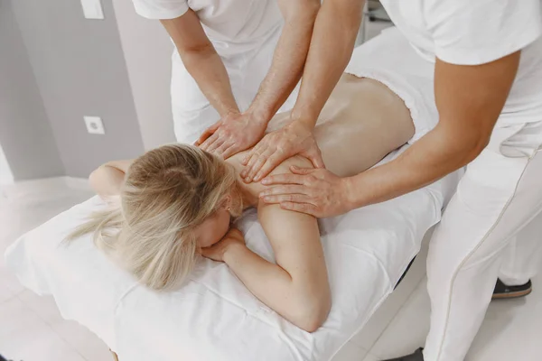 Quatro mãos fazem massagem ao corpo feminino — Fotografia de Stock