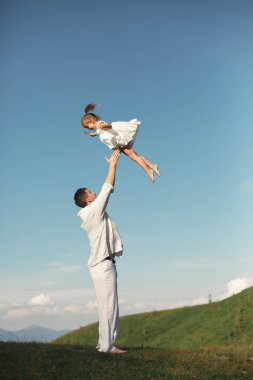 Baba dağlarda küçük kızıyla oynuyor.